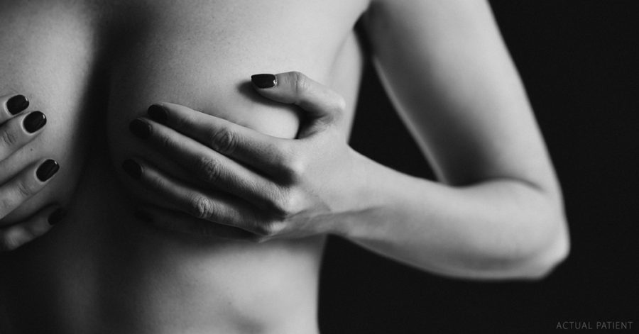 woman holding her breasts in black and white